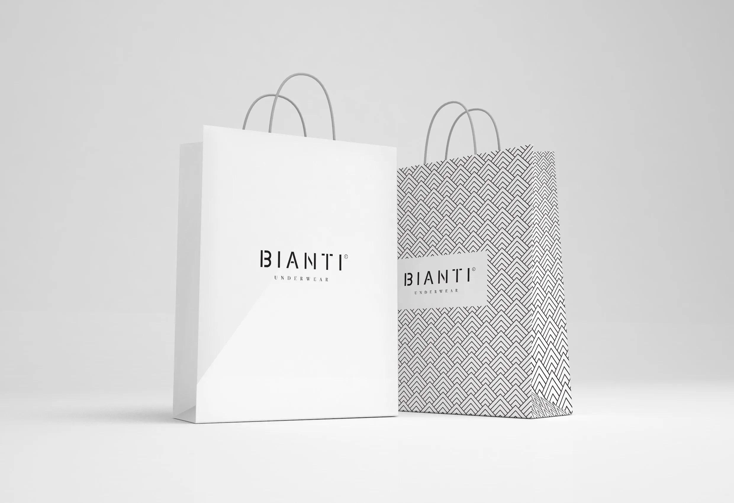Två papperskassar med Biantis logotyp, en vit och en med svartvitt mönster