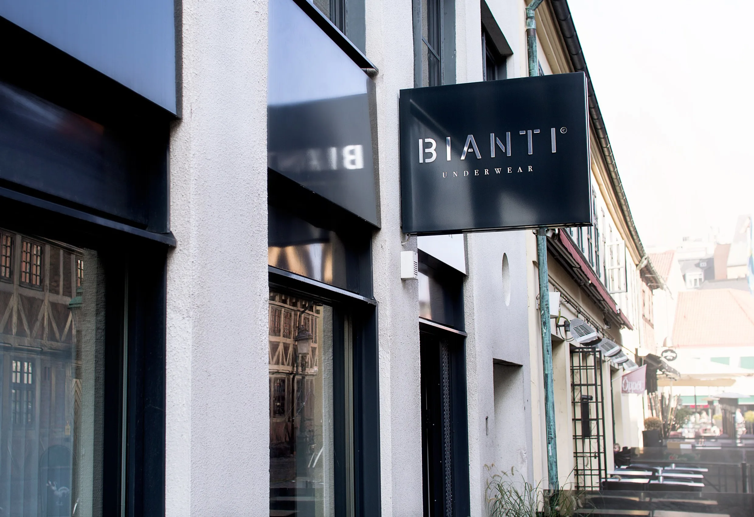 En gatuskylt med Biantis logotyp på en svart skylt vid en husfasad