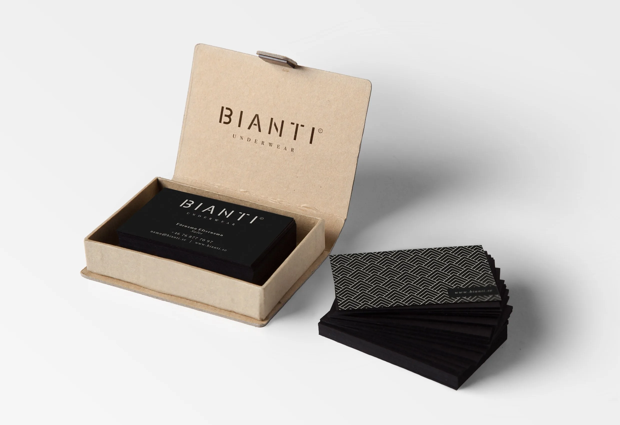 Visitkort i svart med Biantis logotyp, i en kartongask och i en hög