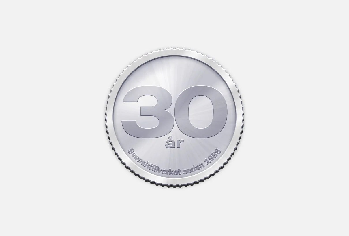En silverfärgad mynt-emblem med texten ”30 år”