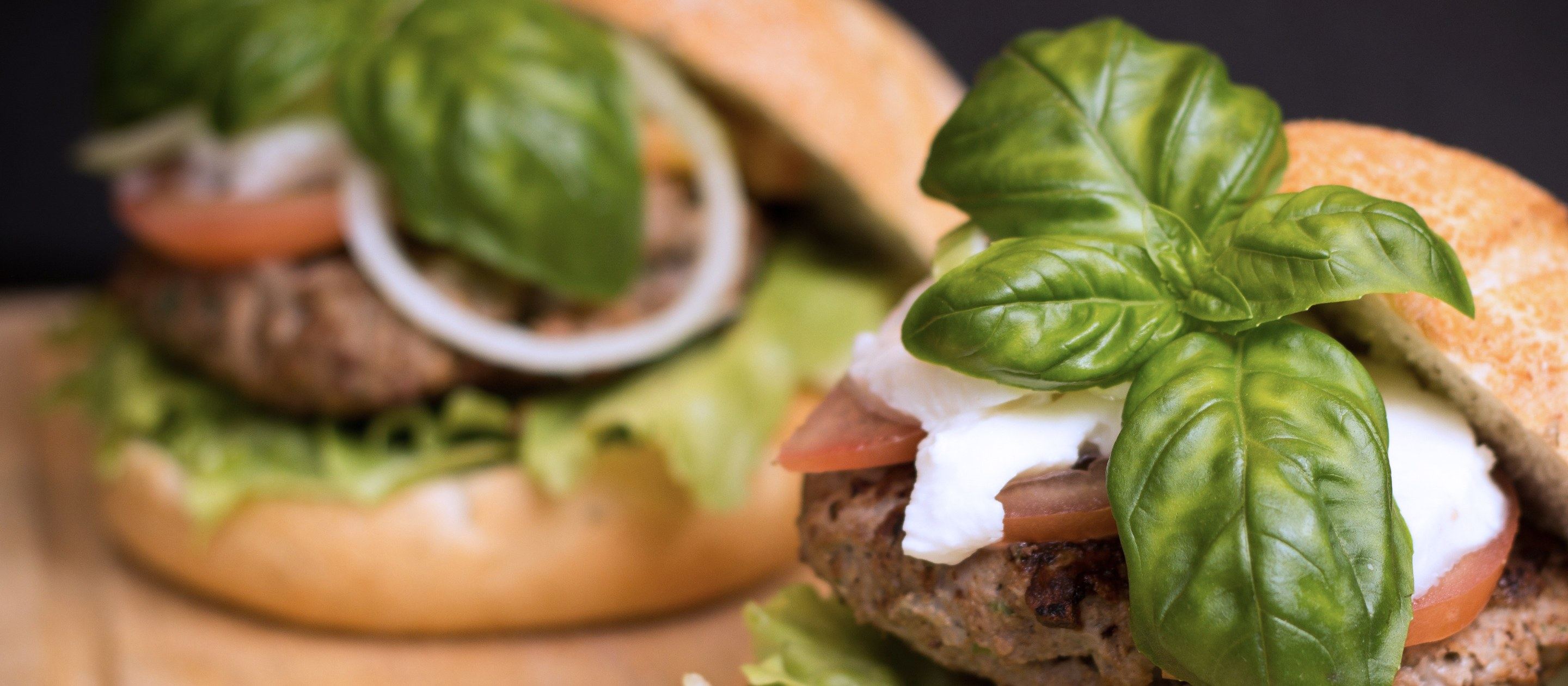 Två hamburgare med sallad och tomat i närbild