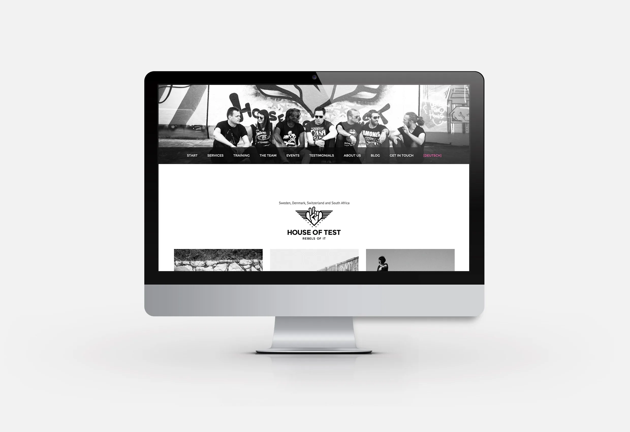 Webbplatsen på en datorskärm: svartvit design med ett grupporträtt och logotypen
