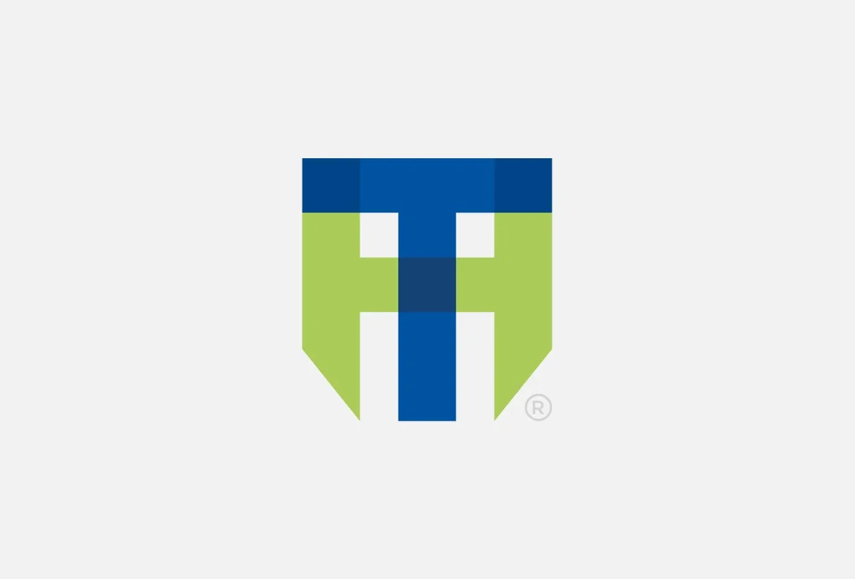 Husie Tandvårds symbol, ett H av gröna och blå fält, på ljusgrå botten