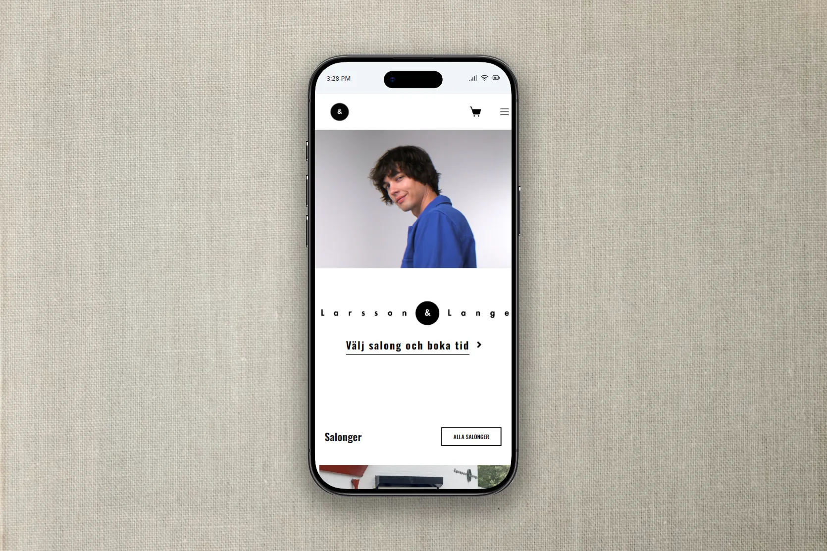 Startsidan på en mobil mot linnetyg: en person i blå skjorta och texten ”Välj salong och boka tid”