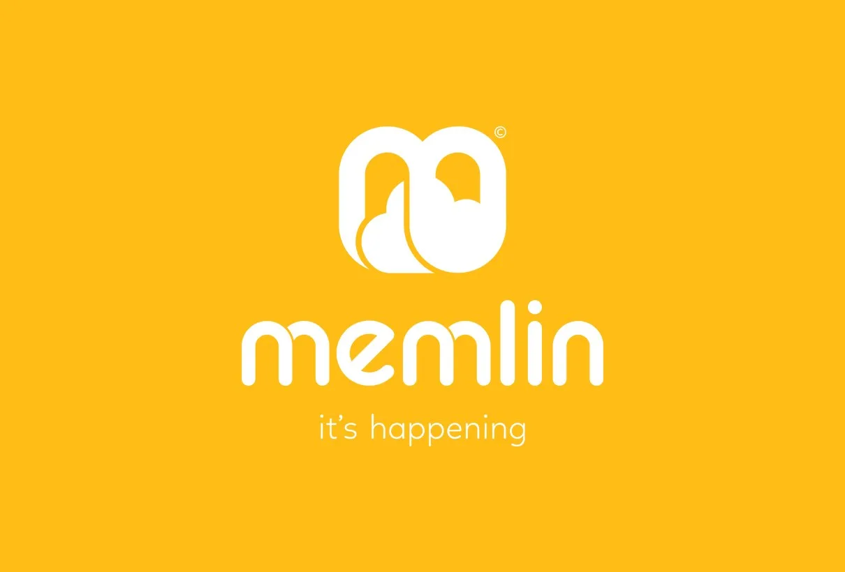Memlins logotyp i vitt på gul botten, med ”it’s happening”