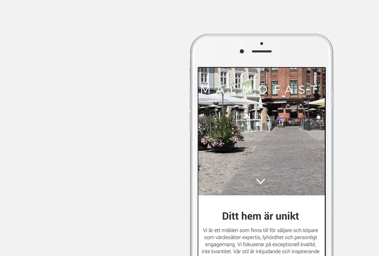 Webbplatsen på en mobil: en bild av ett torg i stadsmiljö och texten ”Ditt hem är unikt”