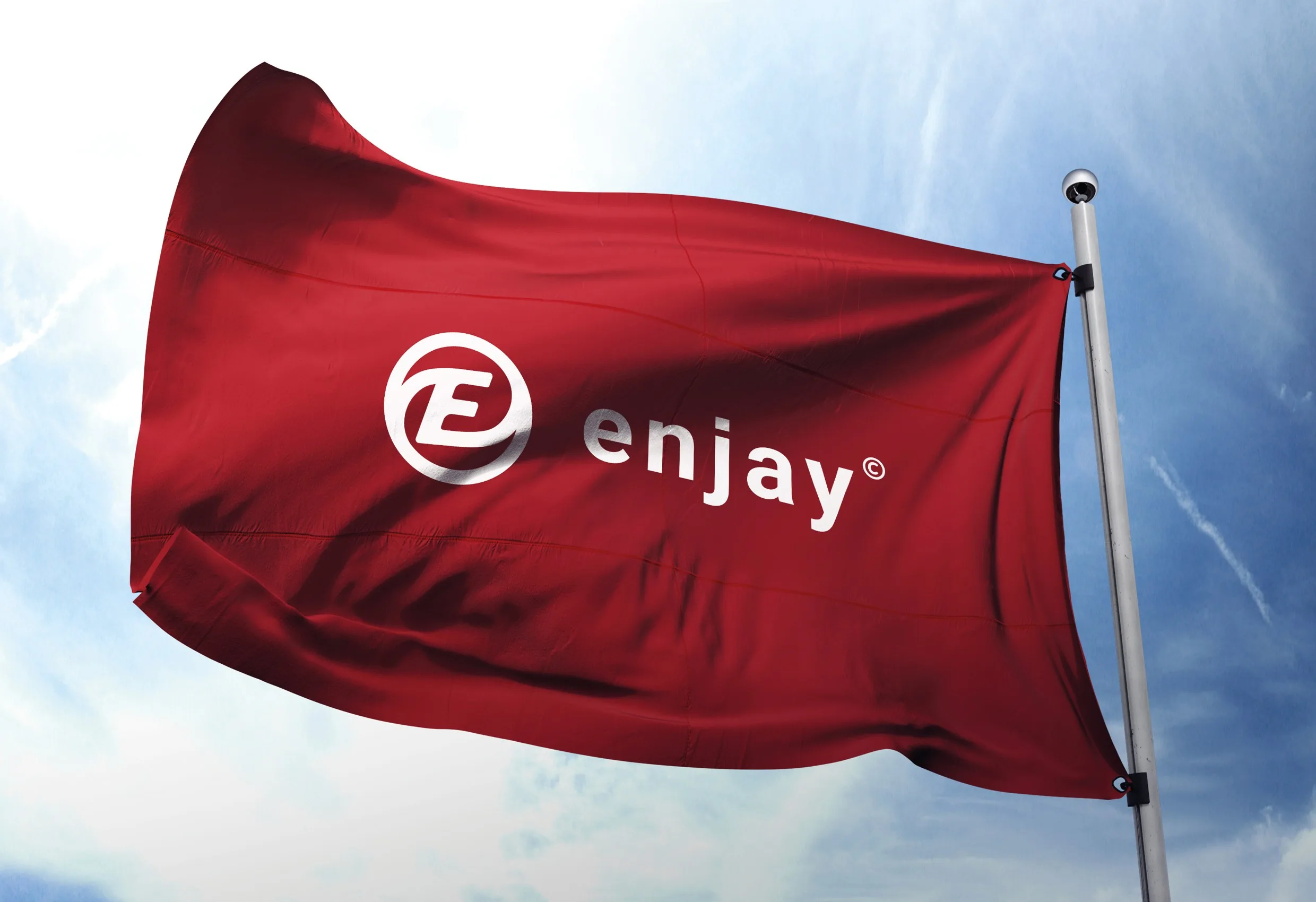 En röd flagga med Enjays logotyp som vajar mot en blå himmel
