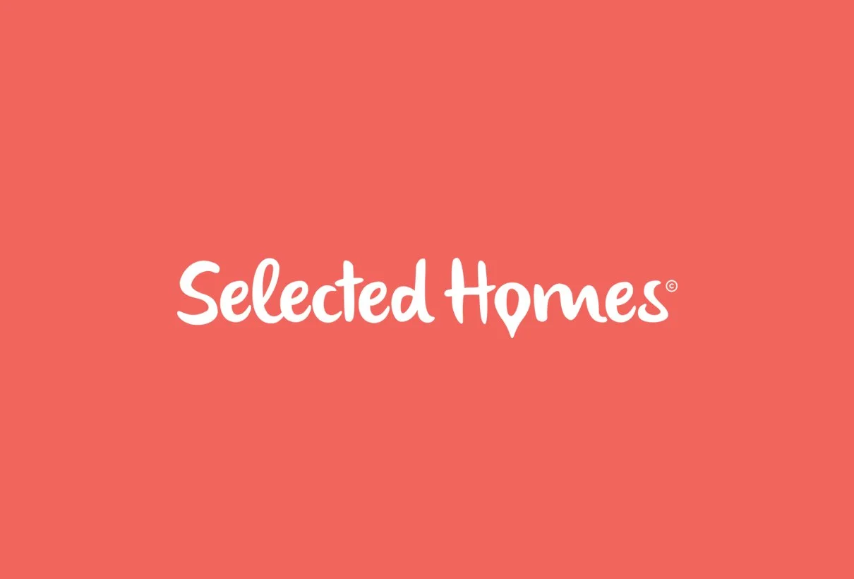 Selected Homes logotyp i vitt på korallröd botten