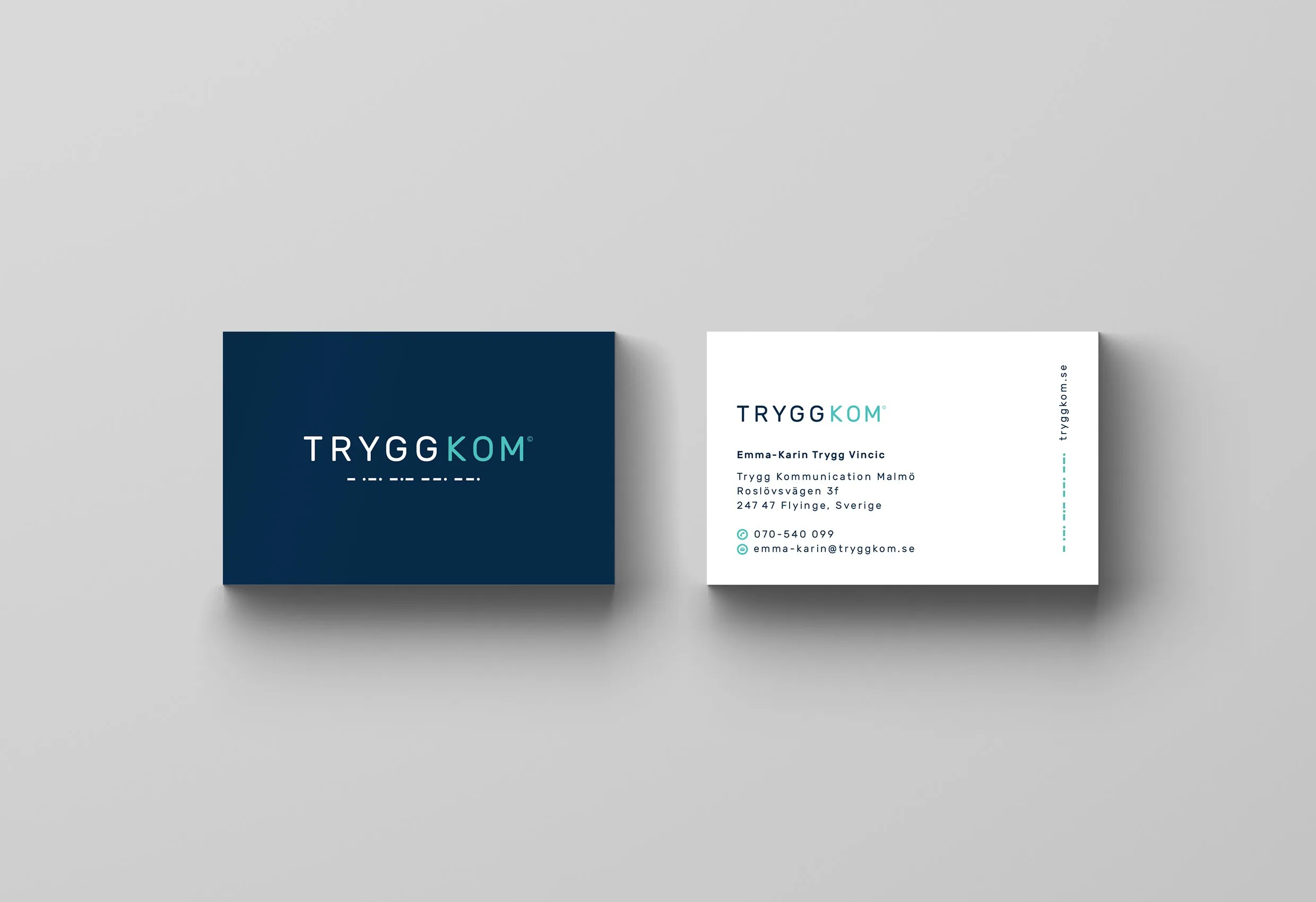 Två visitkort, ett mörkblått och ett vitt, med Trygg Kommunikations logotyp